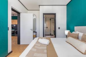 une chambre avec un lit blanc et un mur vert dans l'établissement Nine Palms - Century City Luxury Apartment, au Cap