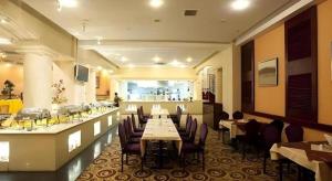 a dining room with tables and chairs in a restaurant at Dunhuang Grand Soluxe Hotel in Dunhuang