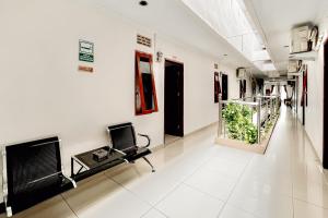 a hospital hallway with a chair and a fireplace at RedDoorz at Vania Residence Medan in Medan