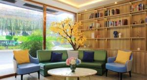 a living room with a couch and two chairs and a table at Vatica Fuzhou West Second Ring Road Xihu Park Hotel in Fuzhou