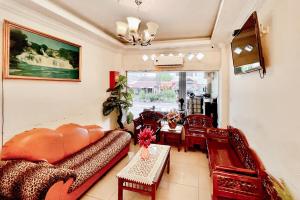a living room with a couch and a table at RedDoorz at Vania Residence Medan in Medan