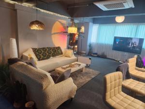a living room with a couch and chairs and a tv at 포항 파티룸 숙박깔끔 in Pohang