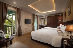 a bedroom with a large white bed and a television at Hanoian Central Hotel & Spa in Hanoi +137 photos