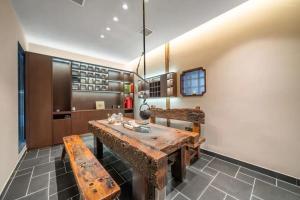 une salle à manger avec une table et des bancs en bois dans l'établissement 三间堂百年徽商俞家 婺源月亮湾店, à Wuyuan