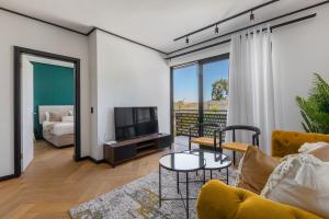 un salon avec un canapé et une télévision dans l'établissement Nine Palms - Century City Luxury Apartment, au Cap