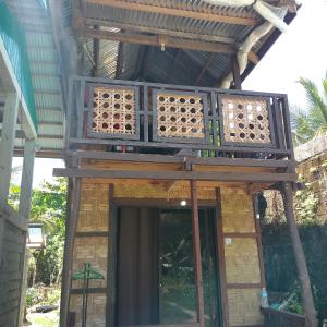 ein Holzgebäude mit Balkon darüber in der Unterkunft Kubo ni klay in San Isidro