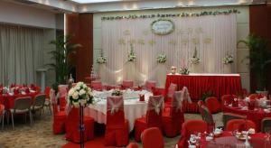 a banquet hall with red tables and chairs and a clock at Ramada Plaza by Wyndham Hangzhou Riverside in Hangzhou +104 photos