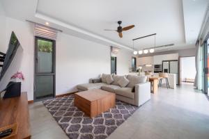 un salon avec un canapé et une table dans l'établissement Nicky Luxury Private Pool Villa in BangTao Laguna, à Laguna Phuket