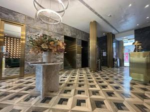 een lobby met een vaas met bloemen op een tafel bij King's Hotel in Hong Kong