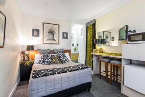 a small bedroom with a bed and a desk at Airport Riverview Motel in Brisbane