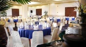 a large room with a blue table and white chairs at M - Regency Hotel in Makassar