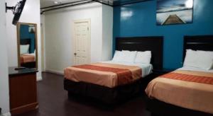 a bedroom with two beds and a blue wall at Stuart Hotel in Los Angeles +11 photos