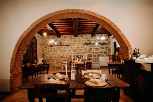 a dining room with a table and a brick wall at Vitalenta Agriboutique in Pienza