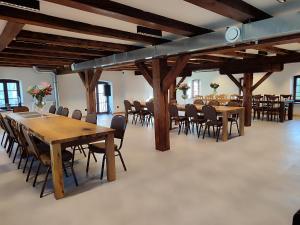 a large room with wooden tables and chairs at Młyn Melzak in Pieniężno