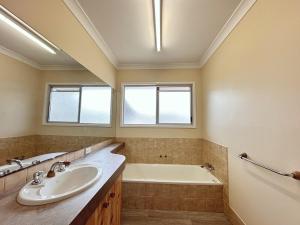 a bathroom with a sink and a bath tub at Relaxing 3Bed Home in Moranbah