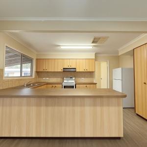a large kitchen with wooden cabinets and a counter top at Relaxing 3Bed Home in Moranbah