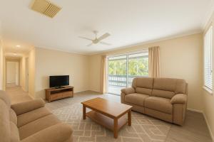 a living room with two chairs and a television at 31 Leichhardt Dr Relaxing 3Bed Home in Moranbah