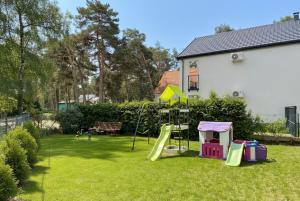 un patio con parque infantil con tobogán en Lawendowe Domki i Apartamenty w Pobierowie, en Pobierowo