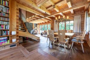 a dining room with a table and chairs and a staircase at Harmony Deluxe Chalet, Sauna & Fireplace by Belle-Stay in Reith bei Kitzbühel