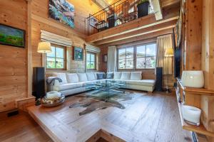 a living room with a couch and a table at Harmony Deluxe Chalet, Sauna & Fireplace by Belle-Stay in Reith bei Kitzbühel