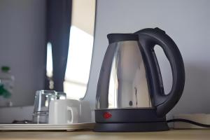 a black tea kettle sitting on a table at X GO INN Chiang Mai University CMU - โกอินน์ เชียงใหม่ in Chiang Mai