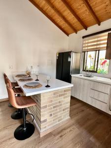 a kitchen with a counter with two wine glasses at Magnífica Cabaña en Pony Parque Mesa de los Santos in Piedecuesta