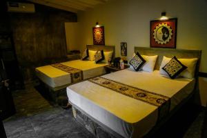 a bedroom with two beds with yellow sheets at Leeza Villa in Dickwella
