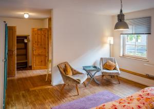 a bedroom with a bed and two chairs and a table at Seeblick Bed & Breakfast in Lassahn