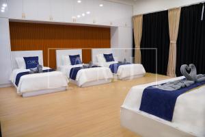 a room with four beds with blue and white sheets at Cyberjaya - Puchong Luxury Private Swimming Pool Villa with BBQ - Corner lot up to 20 Guests in Puchong +77 photos