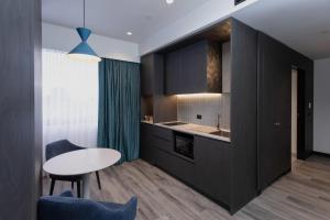 a kitchen with black cabinets and a table at Bayside Geelong Hotel & Apartments, an Ascend Collection Hotel in Geelong