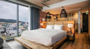 a bedroom with a large bed and a large window at Tropical Hideaway in Seogwipo +44 photos