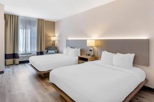a hotel room with two beds and a window at Comfort Inn & Suites Sayre in Sayre