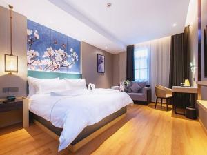 a bedroom with a large bed with a painting on the wall at Jinjiang Inn Wuhan Linjiaohu Wanda Branch in Wuhan +225 photos