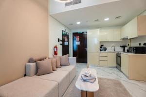 a living room with a couch and a table at Comfortable 1 Bedroom with Balcony Vista 1 in Abu Dhabi +5 photos