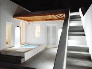 een kamer met een trap en een zwembad bij Thiro Santorini in Fira