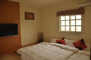 a bedroom with a bed and a flat screen tv at LK Breakfast and Beds in Lukang