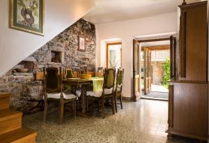 a dining room with a table and a stone wall at Vila Dane in Sežana