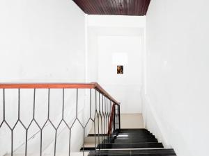 努沙杜瓦Kanha Homestay near Pantai Pandawa RedPartner的一栋白色墙壁的房子里的楼梯