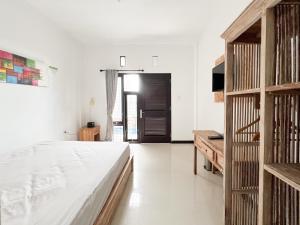 努沙杜瓦Kanha Homestay near Pantai Pandawa RedPartner的一间卧室设有一张床和一个木制书架