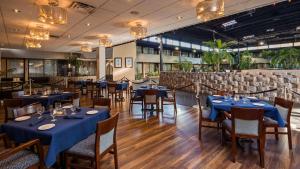 a restaurant with blue tables and chairs in a room at Radisson Hotel Montreal Airport in Saint-Laurent