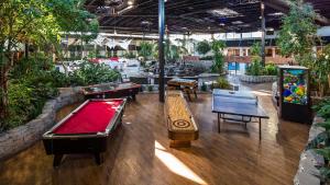 a room with several tables and a pool table at Radisson Hotel Montreal Airport in Saint-Laurent