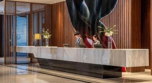 a lobby with two people sitting at a reception desk at Hui Feng Wan Yun Hotel Hefei in Hefei +133 photos