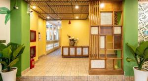 a hallway of a building with green and yellow walls at TRIPLE Riverside Villa Hotel HoiAn in Hoi An +215 photos