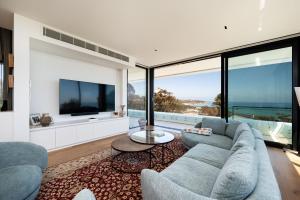 Una sala de estar con un sofá y un televisor. en The Crest - Elevated Luxe with Pool & Spa, en Mount Martha