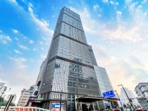 a tall glass skyscraper in a city at Futinger High-altitude River View Hotel in Chongqing