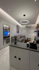 a kitchen and living room with a couch and a table at Luxury 2BR Apartment -Prime Area in Jeddah