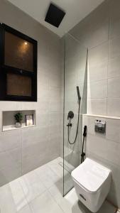 a bathroom with a glass shower and a toilet at Luxury 2BR Apartment -Prime Area in Jeddah +11 photos