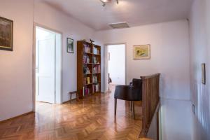 una sala de estar con una mesa y un estante de libros en Vila Dane, en Sežana