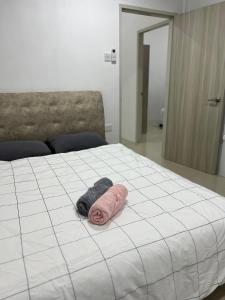 - un lit avec une serviette rose dans l'établissement Mojisu Homestay 麻吉宿, à Miri
