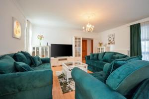 Il comprend un salon doté de canapés bleus et d'une télévision à écran plat. dans l'établissement Dvori Perdedaj, à Beretinec